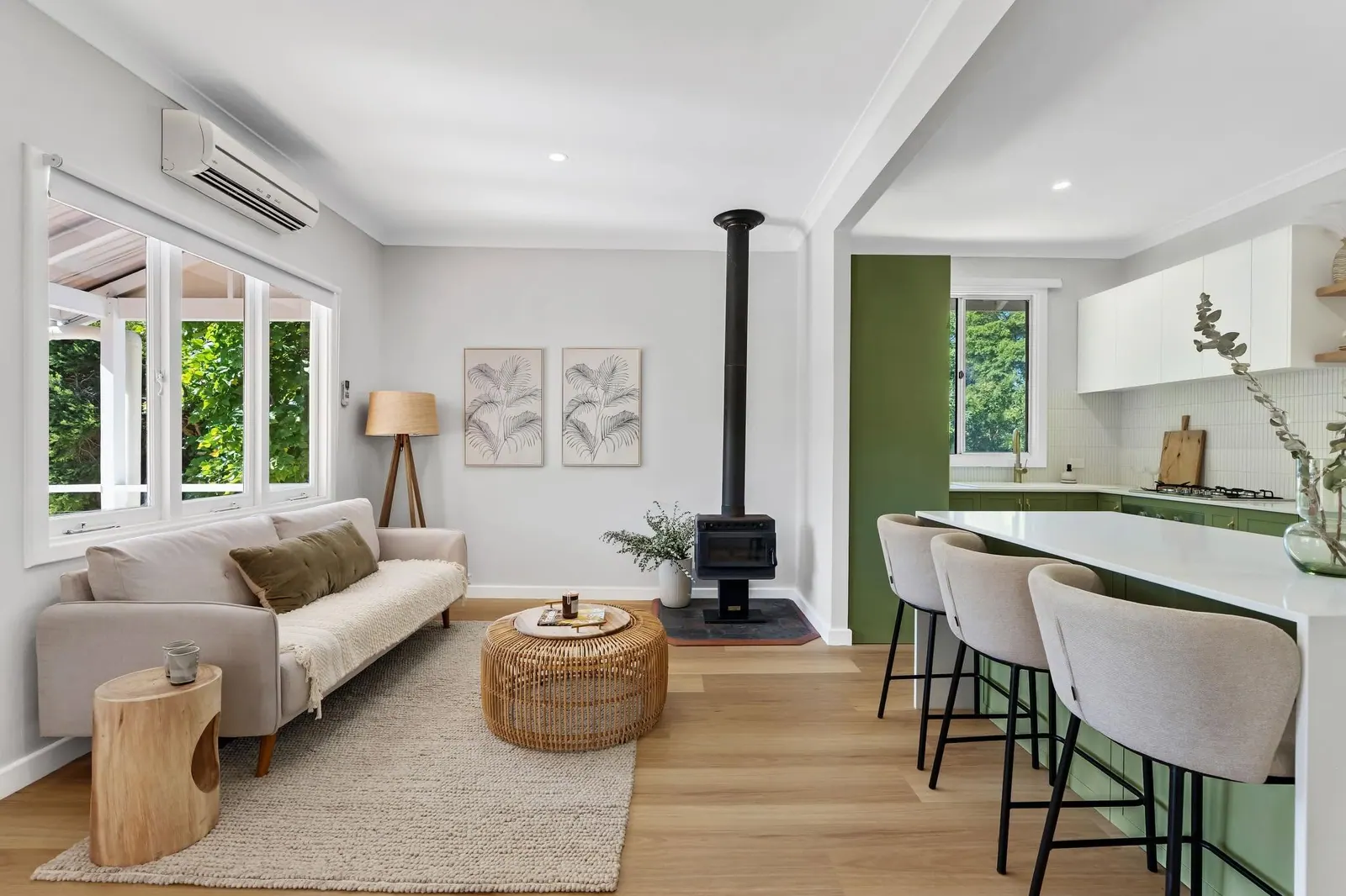 Renovated open-plan living area and green kitchen with timber floors